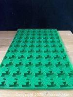 Full view of green silicone mold showing many leaf cavities