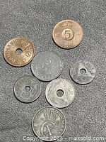 Seven assorted Scandinavian øre coins on dark surface