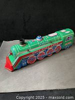 Left side profile of green lithographed tin Puff-Puff Loco train