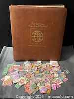 Binder front cover with loose stamps spread in foreground