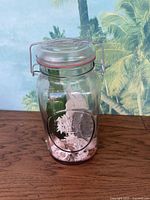 Front view of Ball glass jar with visible seashells, coral and sea glass