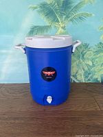 Front view of blue Coleman cooler showing logo sticker and white spigot