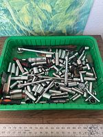 overview of green tub filled with sockets, ratchet, pliers