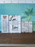 Front view of three wooden wall plaques showing full quotes and sizes