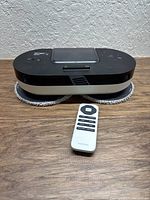 Top and side view of Everybot scrubber with remote placed in front