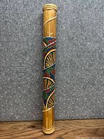 Full view of bamboo rain stick standing upright