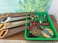 Overall view of four hand saws and tray of assorted tools