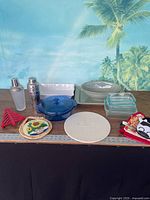 Group shot of all items on table including shakers, dishes, casserole, stone, trivets and pot holders