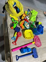 Overall view of assorted plastic beach toys on table