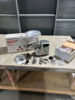 Overall view of grinder, box, accessories laid out on table