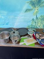 Overview of all cookware, cutting boards and potholders on table