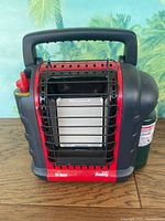 Front view of Mr. Heater Portable Buddy heater with propane cylinder attached