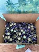 Open box filled with purple NuGrape bottle caps