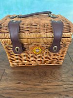 Front view showing wicker basket, leather straps, sunflower emblem