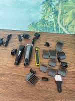 Full lot showing three trimmers, chargers, multiple guards, brush