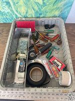 Overview of bin with screwdrivers, tape rolls, connector box, fasteners