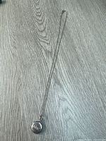 Full view of sterling locket on chain laid flat