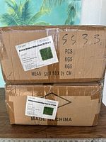 Two cardboard cases labeled Artificial Boxwood Hedge Panel 20x20 inch