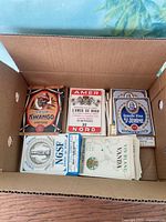 Open box showing five distinct stacks of vintage bottle labels