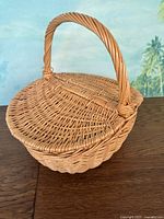 Closed wicker picnic basket showing overall shape and handle