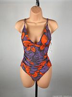 Front view of Le Weekend purple/orange one-piece swimsuit on mannequin