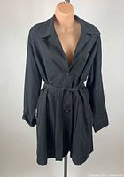 Front view of black trench coat on mannequin