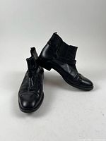Pair of black leather ankle boots, side and top view