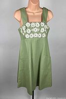 Full front view of green sleeveless dress on mannequin