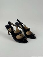 Three-quarter view of both sandals showing leather, strap design, heel height