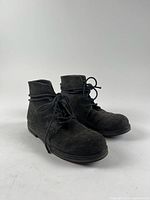 Side view of both boots showing suede texture and lace-up design