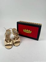 Sandals front view next to branded box