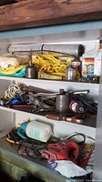 Shelf view showing ropes, oil cans, cleaner cans, vent hose, brake fluid, power tools
