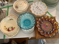 Group shot showing milk glass platter, blue bowl, carnival glass platter, Portland Pottery covered dish and plates, and rectangular platter
