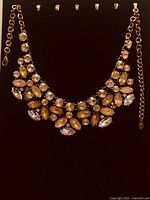 Full view of necklace on display backing showing overall design and extender chain.