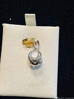 Front view of sterling silver cage charm with clear crystal and yellow-tone bail