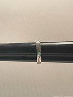 Ring front view on mandrel showing crystal and band detail