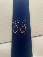 Front view of both sterling silver earrings on display pad