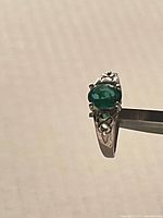 Ring angled view showing green stone and setting details