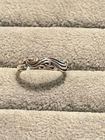 Ring lying flat displaying scrollwork pattern