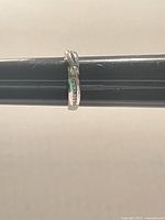 Side view of sterling silver crossover ring on sizing mandrel