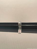 Front view of sterling silver ring on mandrel showing crystal and band design