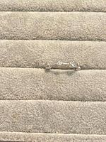 Ring on fabric surface showing band and bezel-set stones