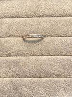 Ring lying on fabric pad showing crystal band detail