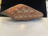 Front view of carved stone showing full etched animal design