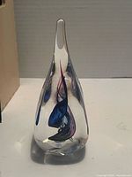Full view of teardrop paperweight standing upright showing internal colors