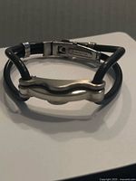 Entire bracelet showing leather cords, stainless steel center bar, and clasp