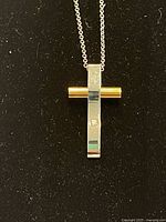 Full view of two-tone cross pendant on chain