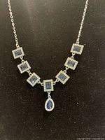 Front view of necklace showing square links and teardrop pendant