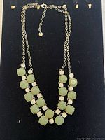 Full view of necklace on display board showing overall design and clasp