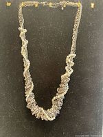 Full view of silver-tone twisted chain necklace hanging
